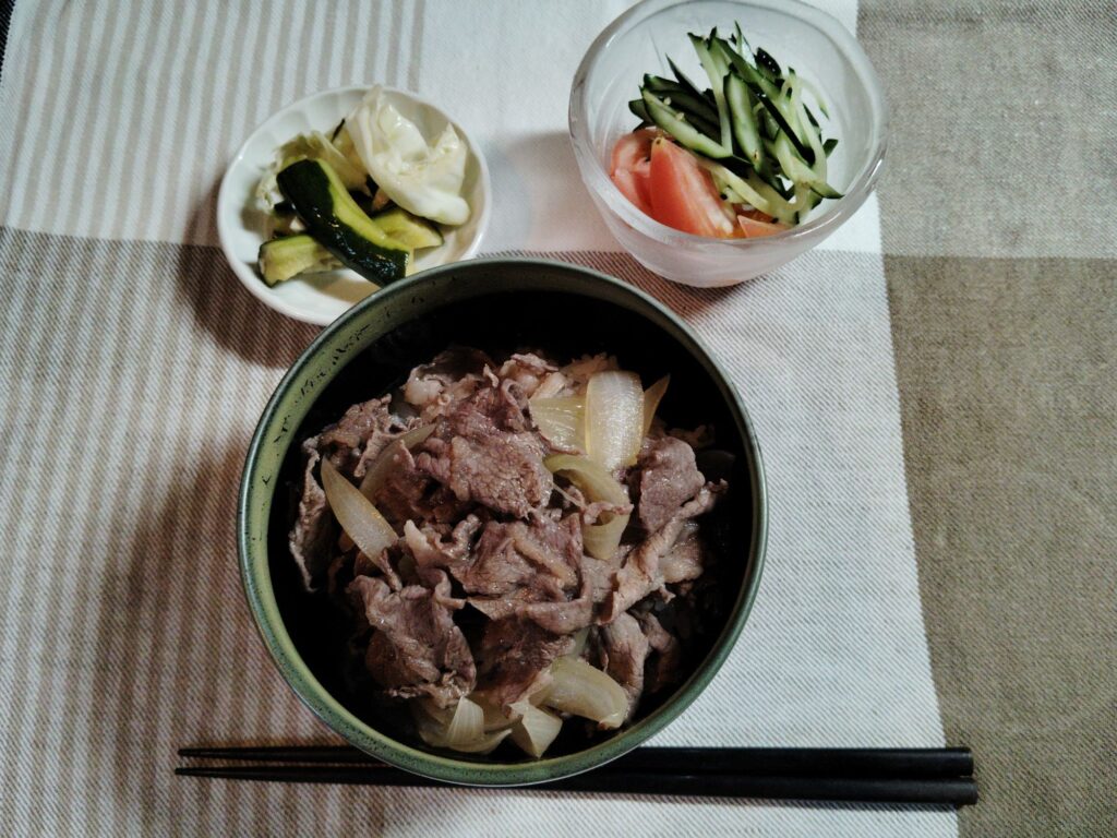 牛丼、きゅうりとキャベツの漬物、千切りきゅうり、くし形トマト。