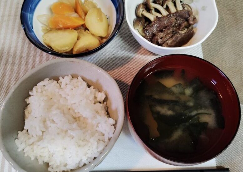 ごはん、ワカメのみそ汁、焼き肉・しめじの焼き肉のタレ絡め、じゃがいも・人参・玉ねぎの煮物。