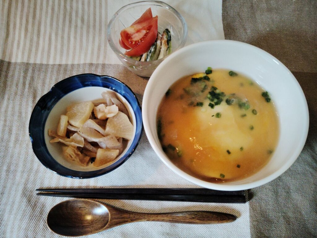 天津飯、こんにゃく・大根・豚ばら肉の煮物、きゅうり漬け、トマト。