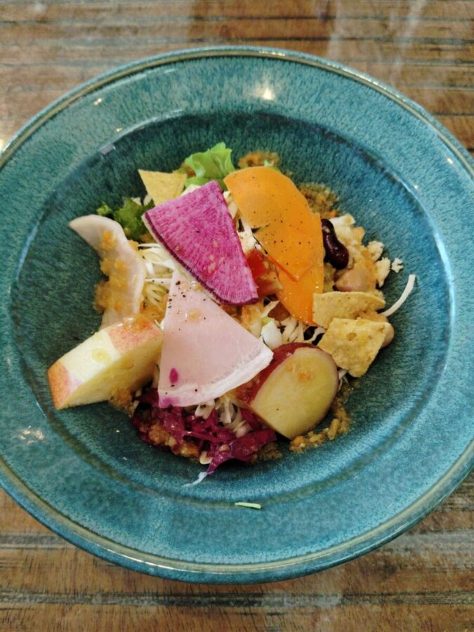 具だくさんのサラダ。キャベツ、レタス、大根、人参、ハム、サラダ豆、サツマイモ甘煮、リンゴ、クリームチーズ。