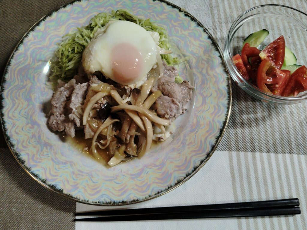 豚肉生姜焼き、玉ねぎ、エリンギ、千切りキャベツ、目玉焼き、きゅうり、トマト。