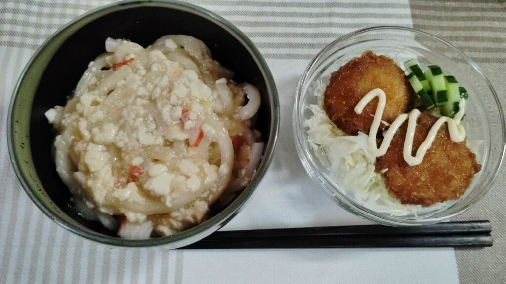 豆腐あんかけうどん(カニカマ)。レンチンチキンカツ。千切りキャベツ、きゅうり。