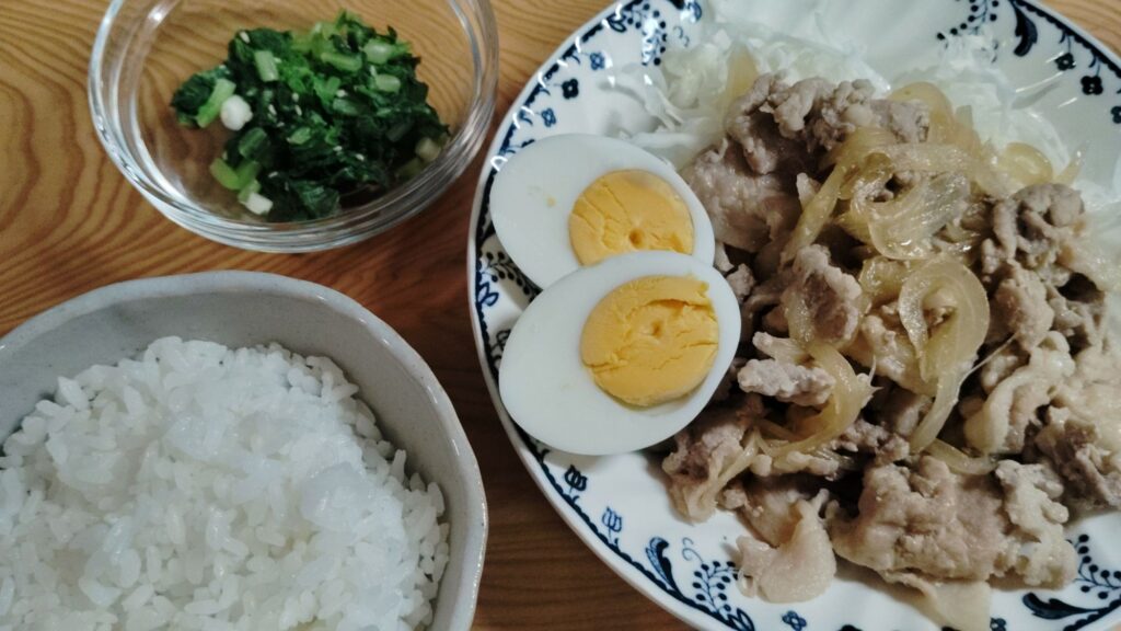 豚肉生姜焼き。千切りキャベツ。ゆで卵。大根のおひたし。