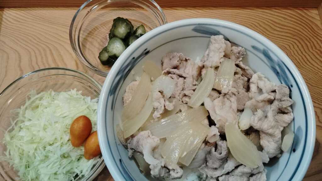 豚丼。きゅうりのぬか漬け。千切りキャベツ。ミニトマト。