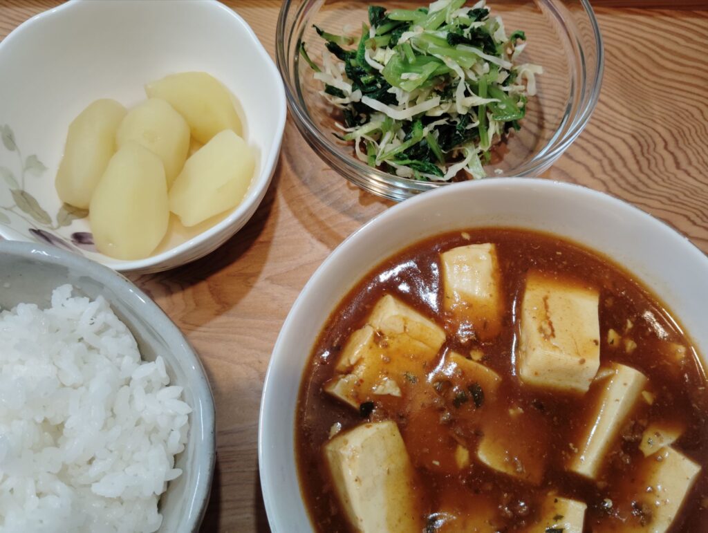 ごはん。市販の麻婆豆腐。大根の間引き菜とキャベツの和え物。じゃがいもの煮物。