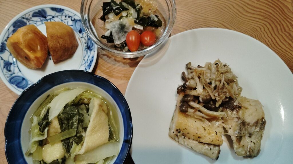 鱈のレモンペッパーソテー・きのこのソテー。白菜・小松菜・あげの煮物。大根・わかめ・中華クラゲの和え物。ミニトマト。柿。