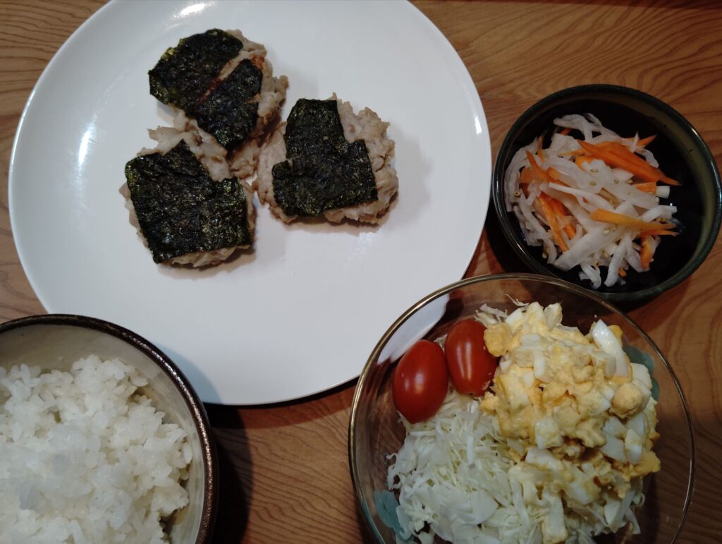 ごはん。ねぎとろつくね。紅白なます。千切りキャベツ・たまごサラダ・ミニトマト。