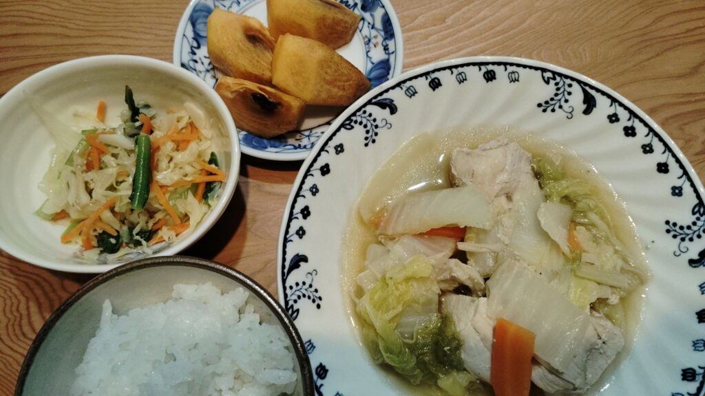 ごはん。鶏肉と白菜のうま煮。キャベツ・小松菜・人参の中華風サラダ。柿。