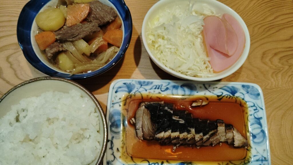 ごはん。かつおのたたき。肉じゃが。千切りキャベツ・ハム。