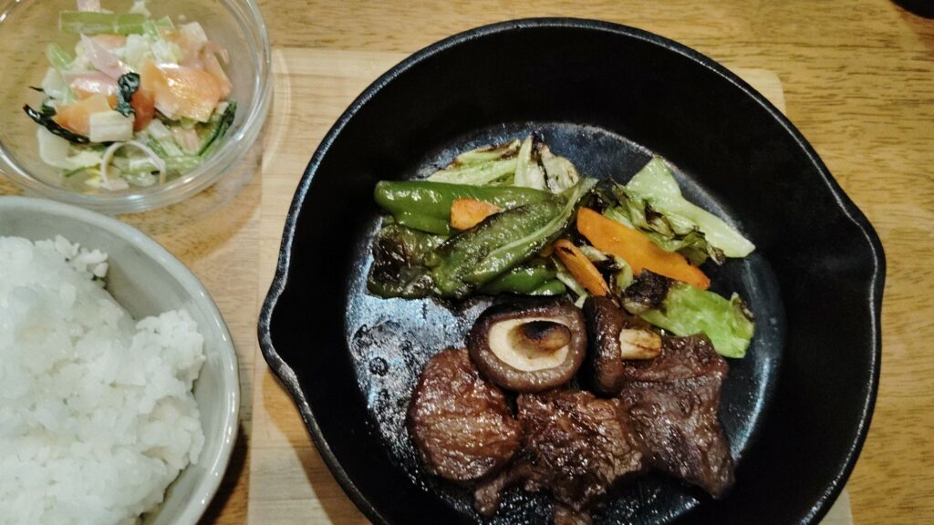 ごはん。スキレット焼き肉(牛肉、シイタケ、キャベツ、人参、ピーマン)。マヨネーズサラダ(ハム、わかめ、白菜、小松菜、人参)。