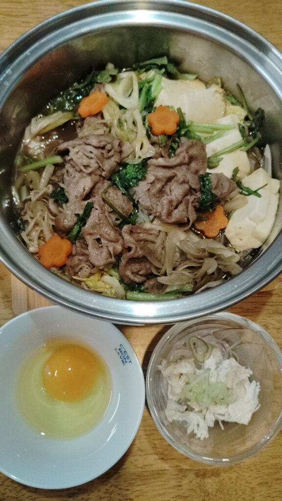 すき焼き(牛肉、とうふ、春菊、白菜、人参、ごぼう、えのき、こんにゃく)生卵。とり酢(鶏肉、春雨、ネギ)。