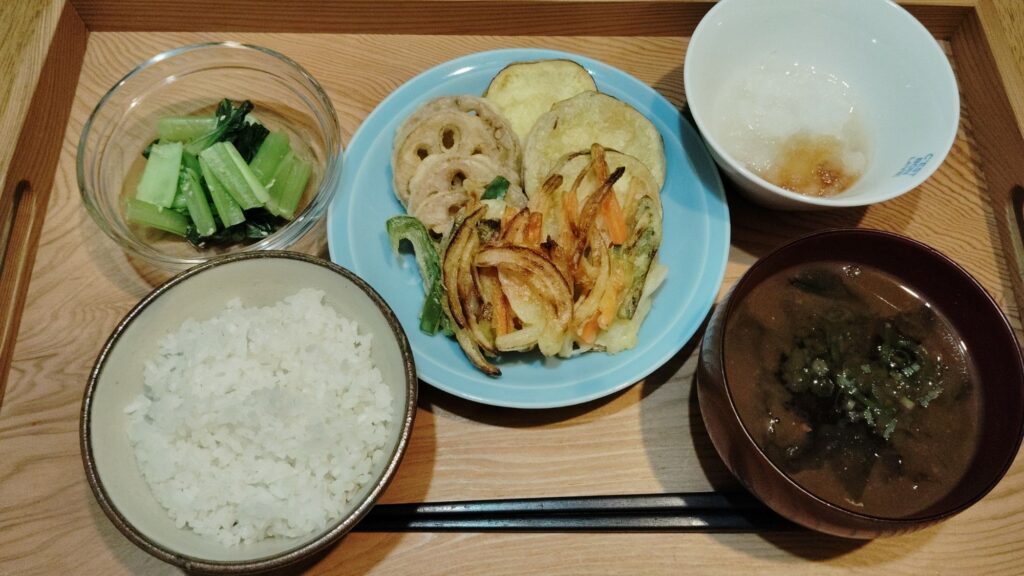 ごはん。さつまいも・れんこんの天ぷら、玉ねぎ・人参・ピーマンのかき揚げ、大根おろし。小松菜の和え物。わかめのみそ汁。