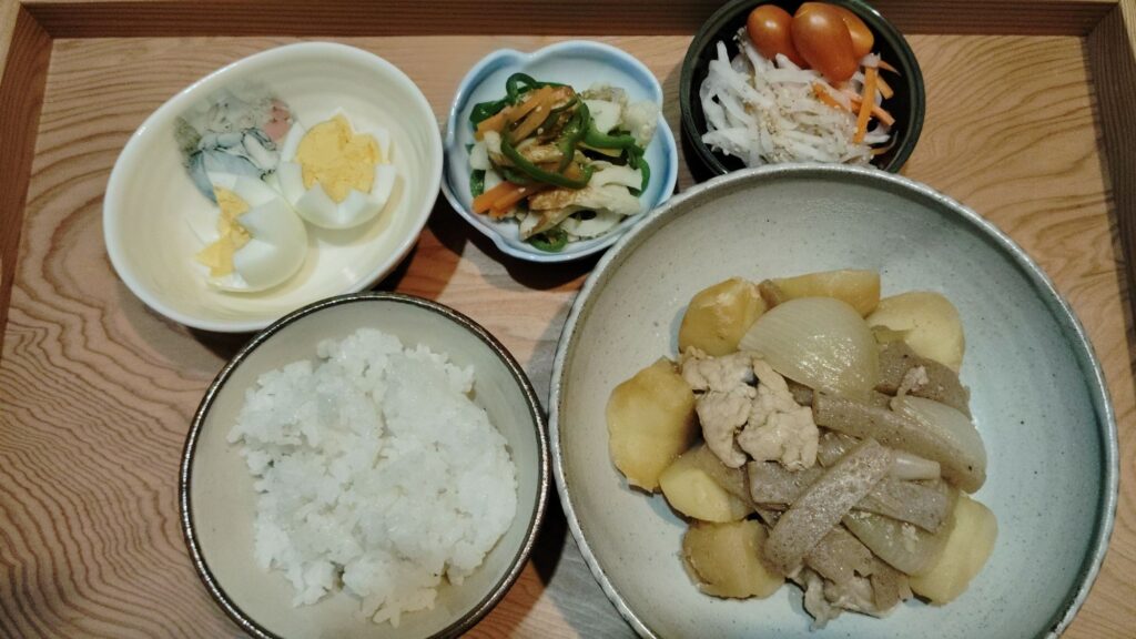 ごはん。肉じゃが。ピーマン・人参・ちくわのきんぴら。なます。ミニトマト。ゆで卵。