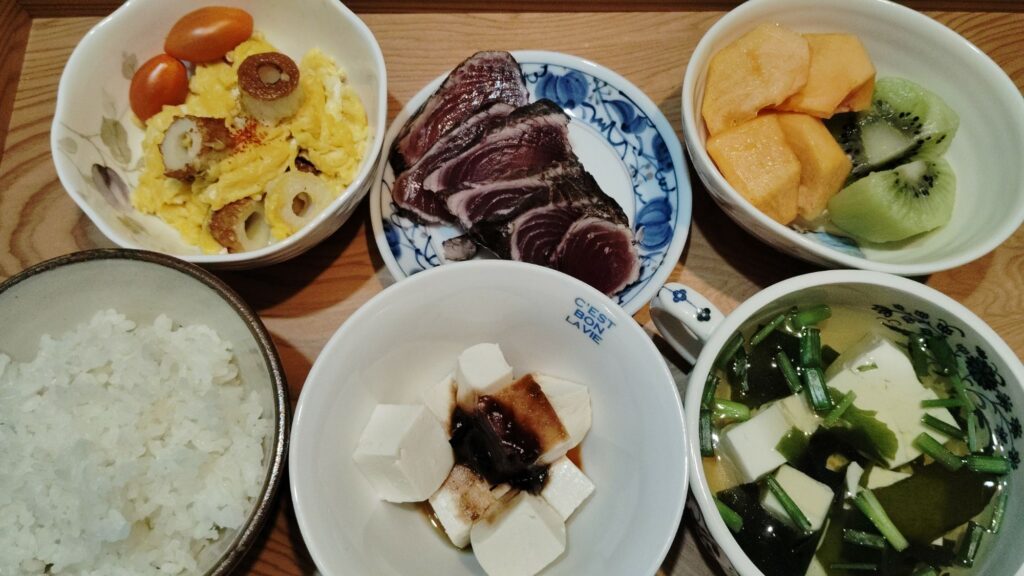 ごはん。かつおのたたき。湯豆腐、味噌だれ。豆腐とわかめの澄まし汁(ねぎ)。ちくわと卵炒め。ミニトマト。柿。キウイ。