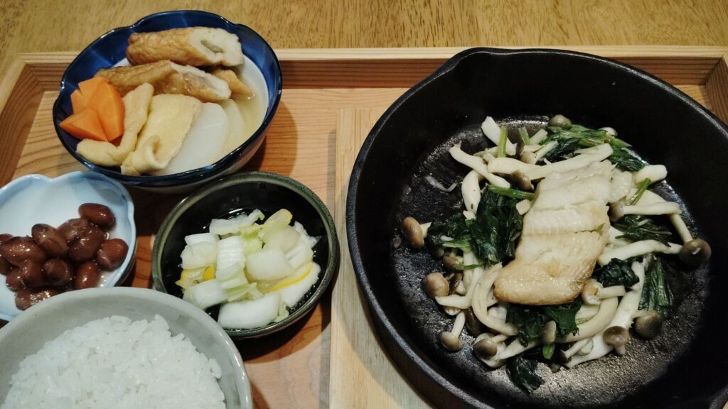 ごはん。ホッケ。ほうれん草ときのこのバター炒め。大根と人参とごぼう天の煮物。煮豆。白菜の漬物。