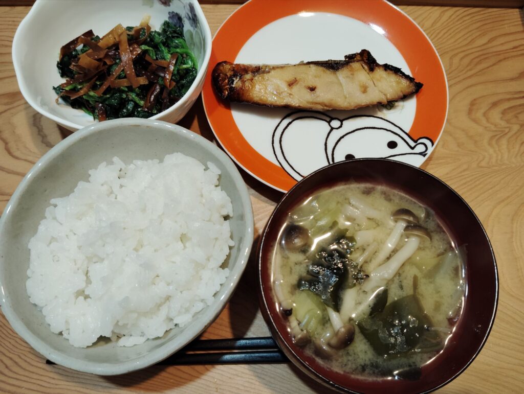 ごはん。シルバー醤油みりん漬け焼き。ほうれん草のごま和え（ワンタンの皮の素揚げ）。みそ汁（キャベツ、わかめ、しめじ）。