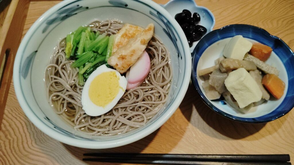 年越しそば(ゆで卵、ほうれん草、かまぼこ、鶏肉)。筑前煮(こんにゃく、ごぼう、れんこん、人参、里芋、高野豆腐)
。黒豆。