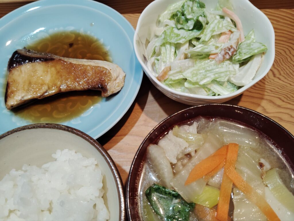 ごはん。ぶりの照り焼き。豚汁（豚肉、大根、白菜、人参、春菊、長ネギ、しいたけ、里芋）。くずきりのサラダ（レタス、ちくわ、人参）。