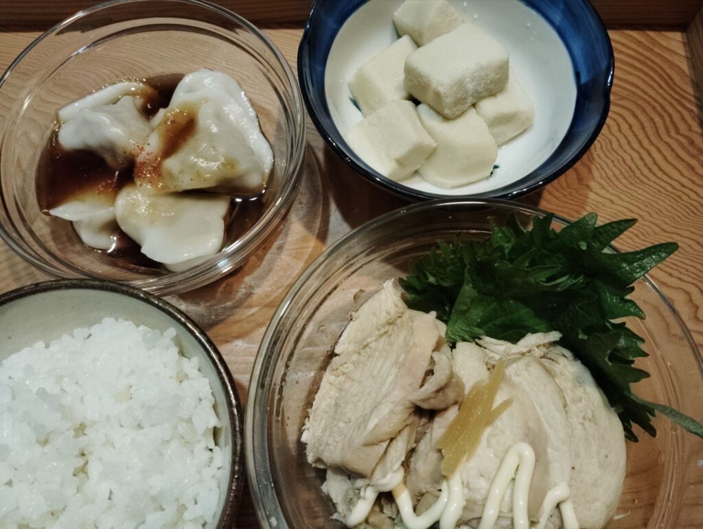 ごはん。鶏チャーシュー、千切りキャベツ、しそ.。水餃子よだれ鶏のタレ。高野豆腐。