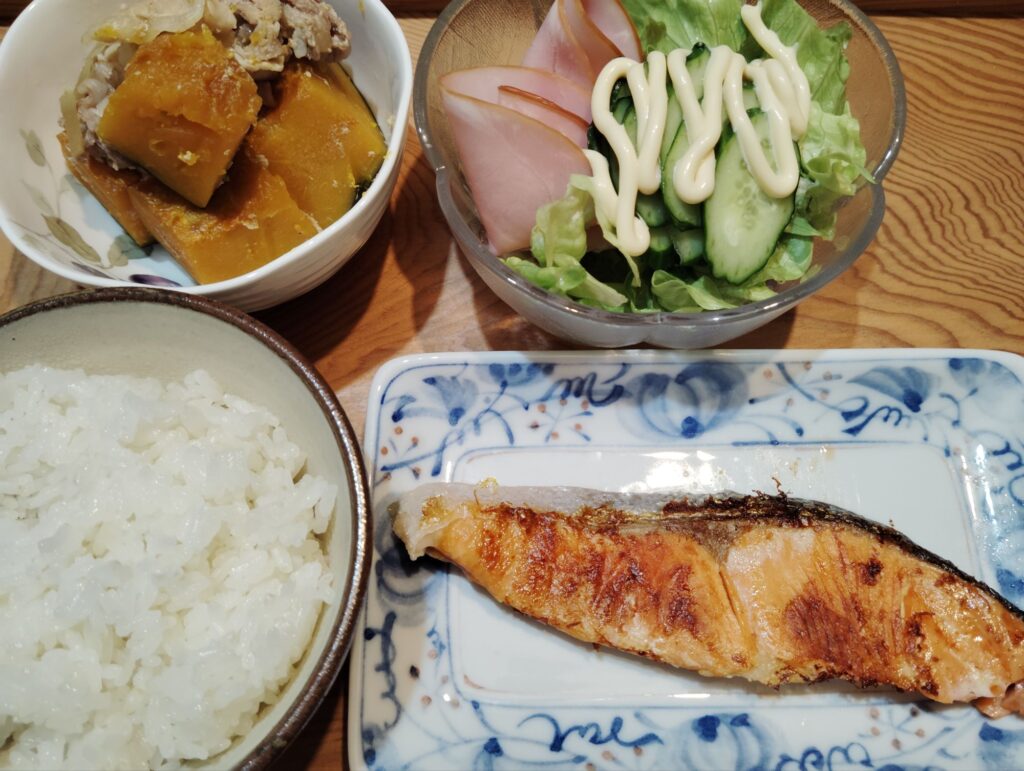 ご飯。鮭。かぼちゃの煮物（豚肉）。サラダ（レタス、きゅうり、ハム）