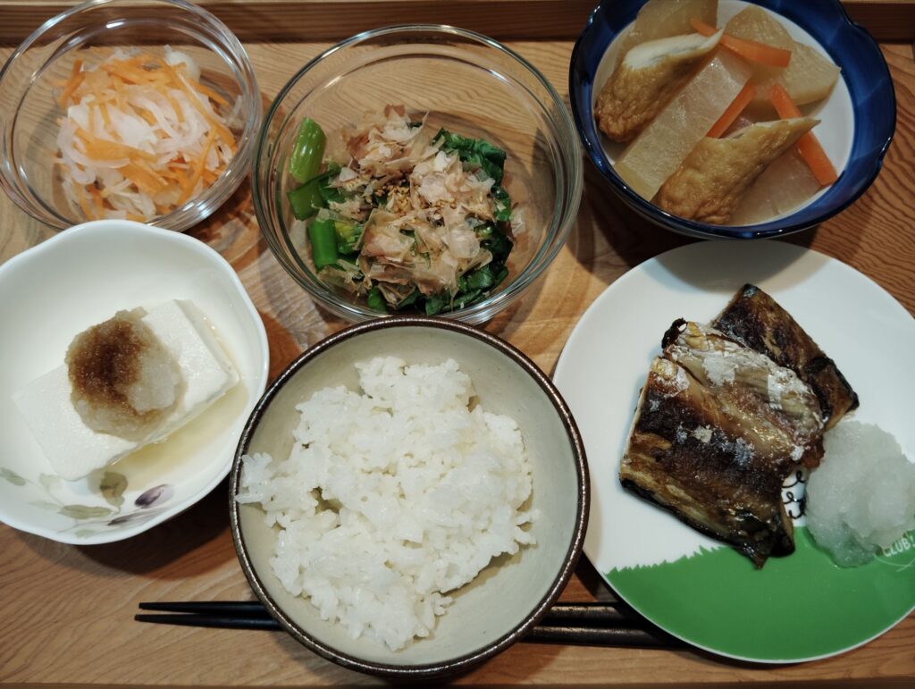 ご飯。焼きサバ。とうふ、大根おろし。小松菜のおひたし。なます。大根、人参、ごぼう天の煮物。