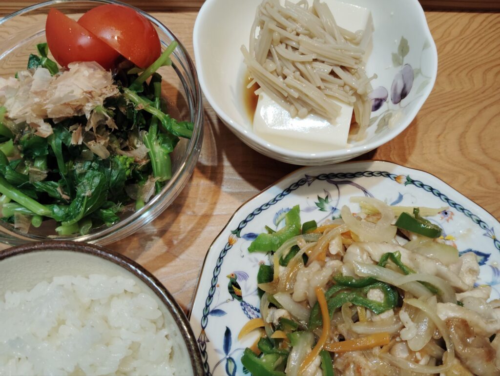 ご飯。チンジャオロース。とうふ、なめたけ。小松菜の菜の花の和え物、トマト。