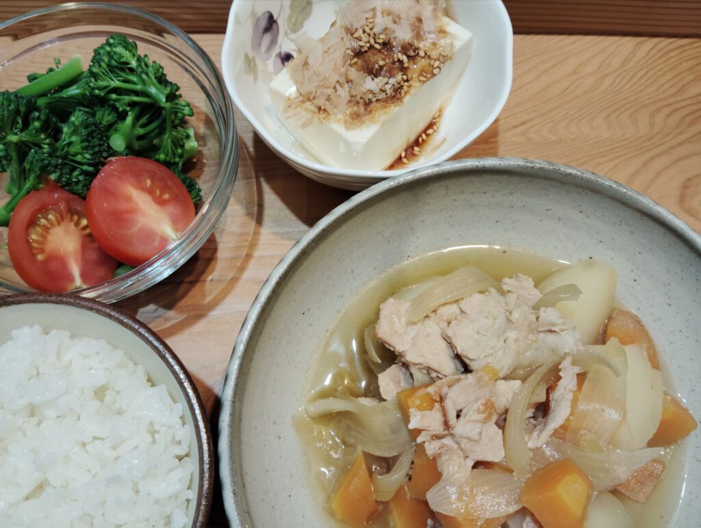 ご飯。肉じゃが。とうふ、かつお節。ゆでブロッコリー、トマト。