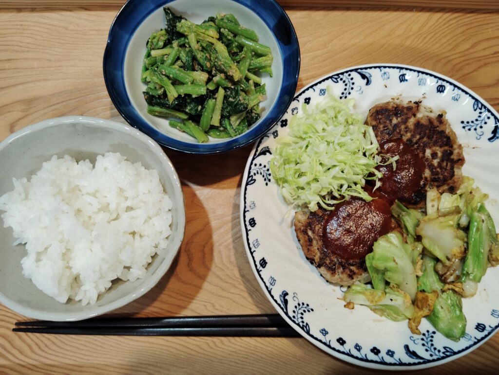 ご飯。ハンバーグ、千切りキャベツ、キャベツと卵の炒め物。ほうれん草のごま和え。