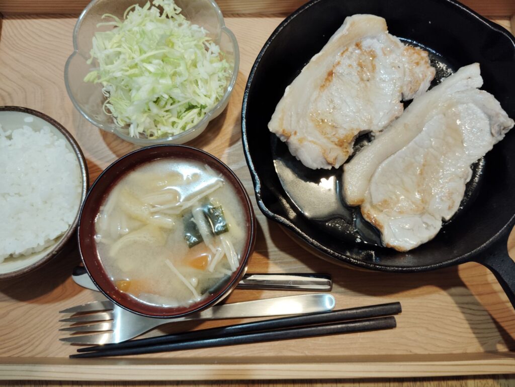 ご飯。豚肉ソテー。千切りキャベツ。みそ汁（ごぼう、えのき、あげ、わかめ、人参）