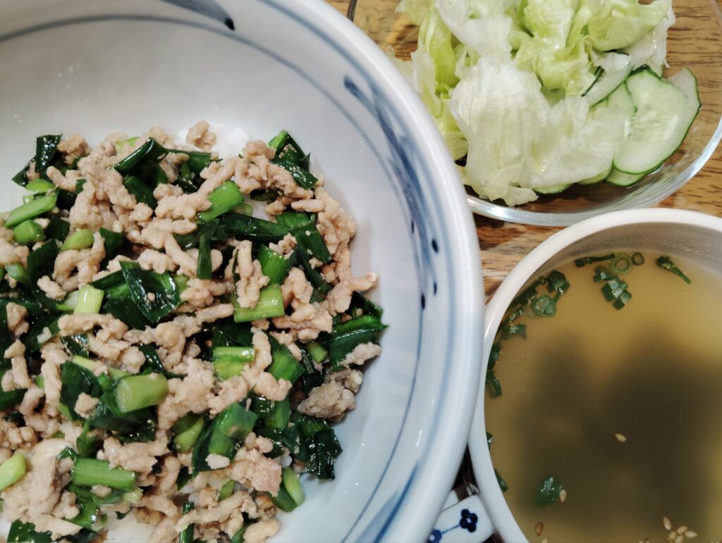 ひき肉とニラのスタミナ丼。スープ(わかめ、ねぎ、ごま)サラダ(レタス、きゅうり)。