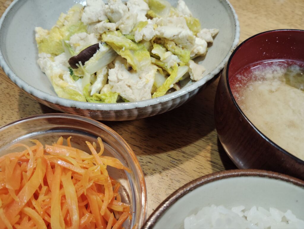 ご飯。みそ汁。お豆腐入り白菜の煮物。人参ラぺ。