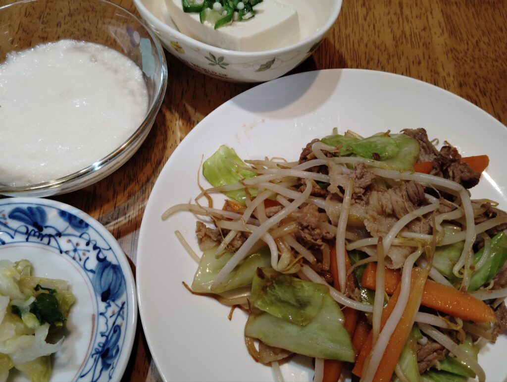 野菜炒め（豚肉、キャベツ、人参、もやし）。冷奴（冷凍オクラ）。長芋のとろろ。市販の白菜漬け。