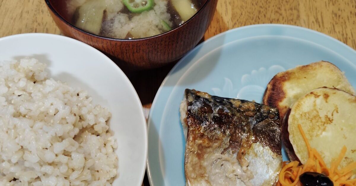 玄米ご飯。ナスとオクラのみそ汁（あげ）。さばの塩麴漬け。さつま芋の天ぷら。人参ラぺ。黒豆。