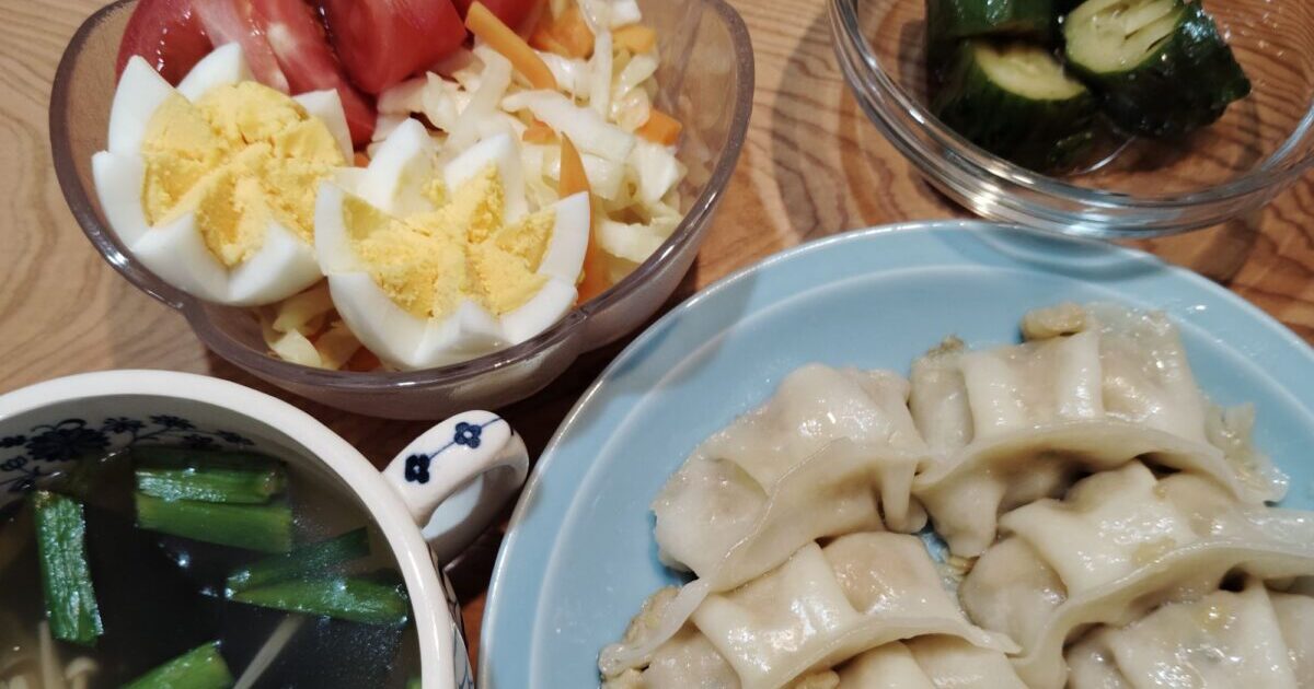 餃子。わかめスープ（ニラ、えのき）キャベツ人参コールスロー、ゆで卵、トマト。きゅうり漬け。
